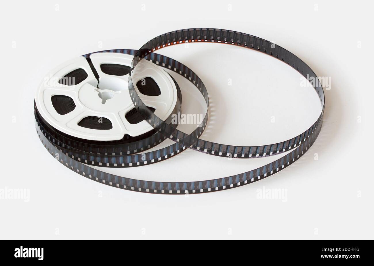 bobine de film de 8 mm avec bandes de film dispersées. Studio shot, gros plan isolé sur fond blanc. Banque D'Images