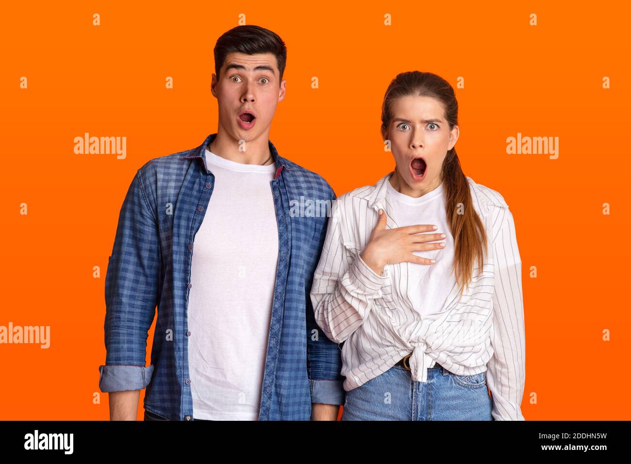 Jeune couple surpris avec des bouches ouvertes regardant la caméra Banque D'Images