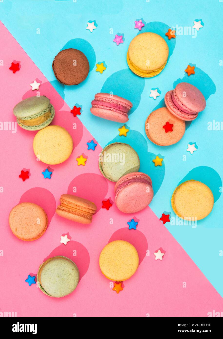 Macarons bonbons de différentes couleurs placés sur un rose et Macarons colorés à motif bleu Banque D'Images