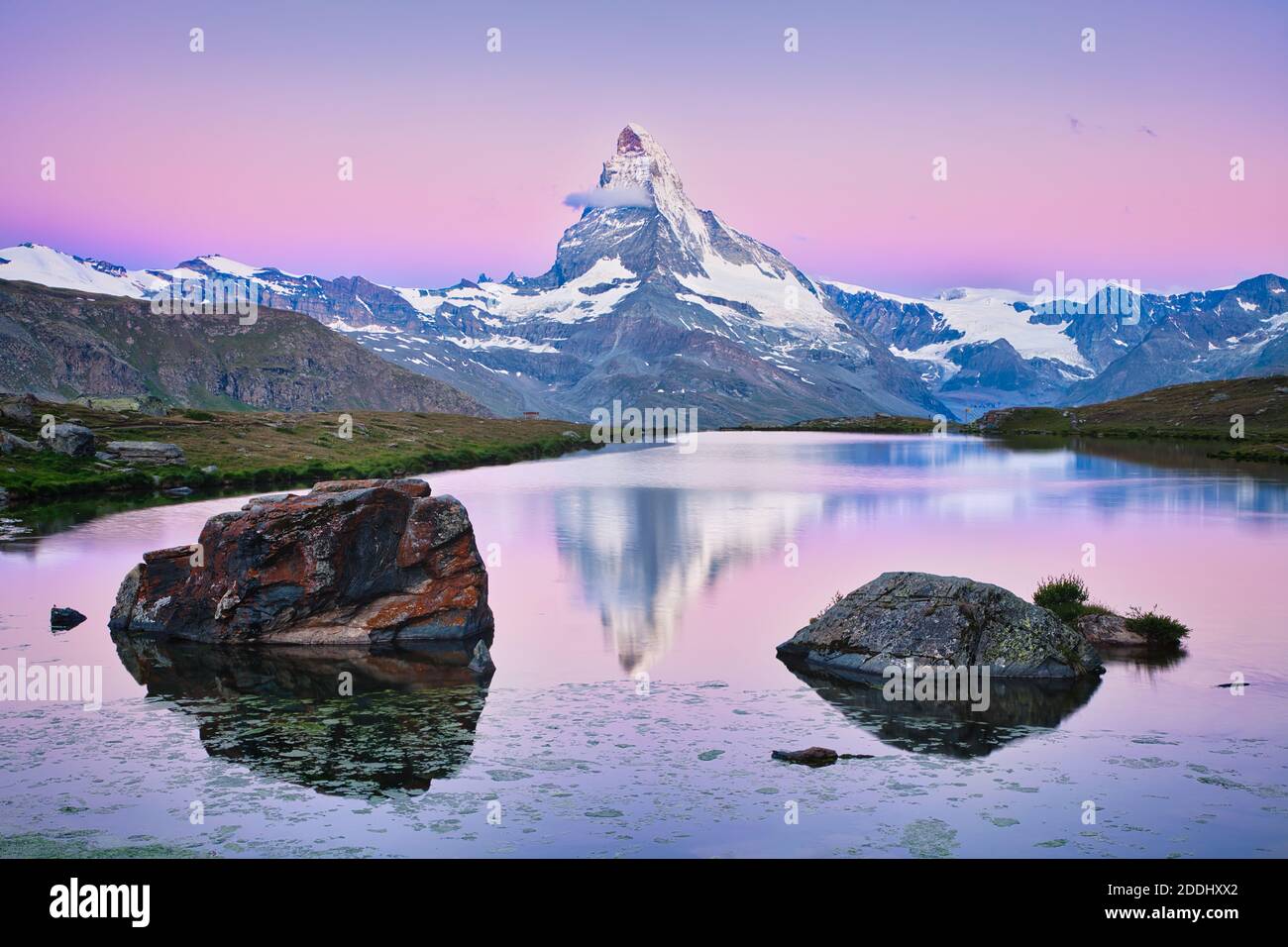 Le sommet de la montagne du Cervin au lever du soleil avec réflexion dans l'eau du lac Stellisee avec de grands rochers au premier plan à Zermatt en Suisse. Banque D'Images