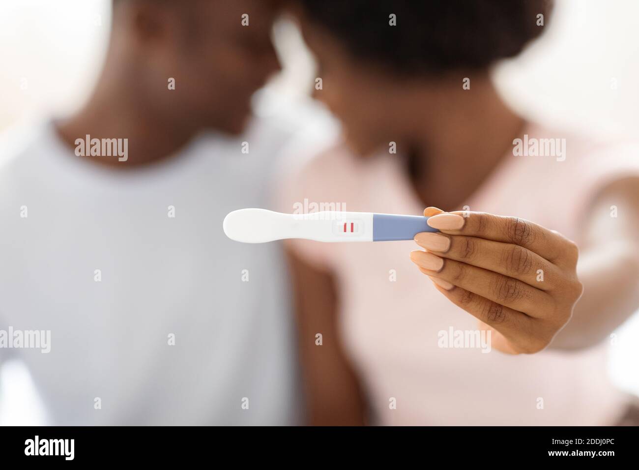 Gros plan du test de grossesse positif dans les mains de la femme noire Banque D'Images