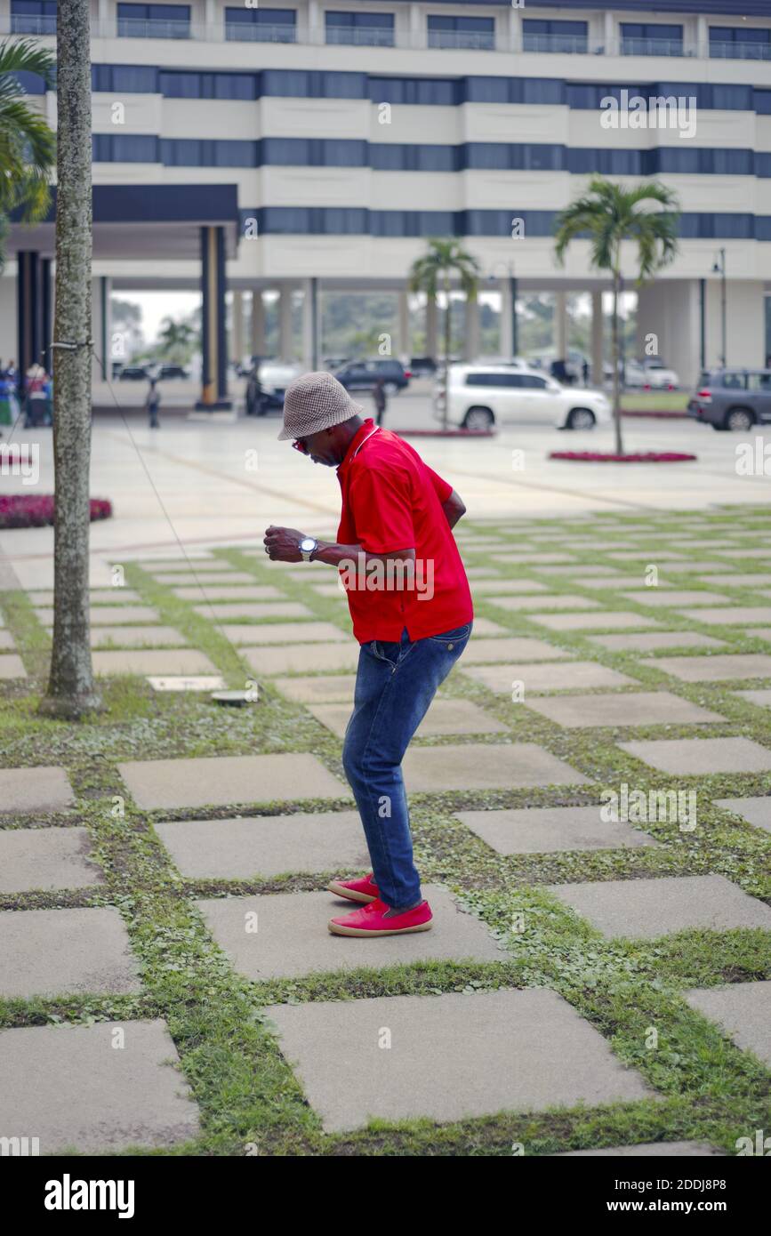 Homme noir avec un chapeau et une chemise rouge dansant Banque D'Images