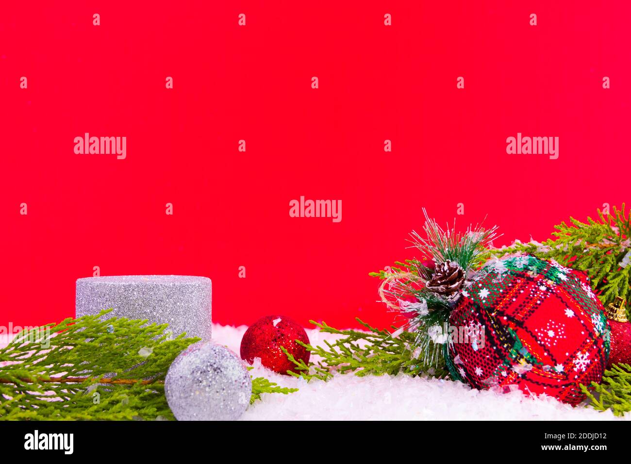 Gros plan sur la décoration du nouvel an sur fond rouge : pin, ornements brillants et bougies pour Noël comme une carte de célébration Banque D'Images