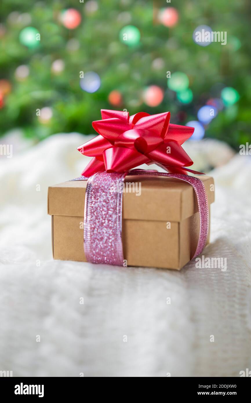 magnifique boîte cadeau surprise festive ornée d'un noeud rouge Un arrière-plan bokeh et près de l'arbre de Noël pour nouveau année et saint-valentin Banque D'Images