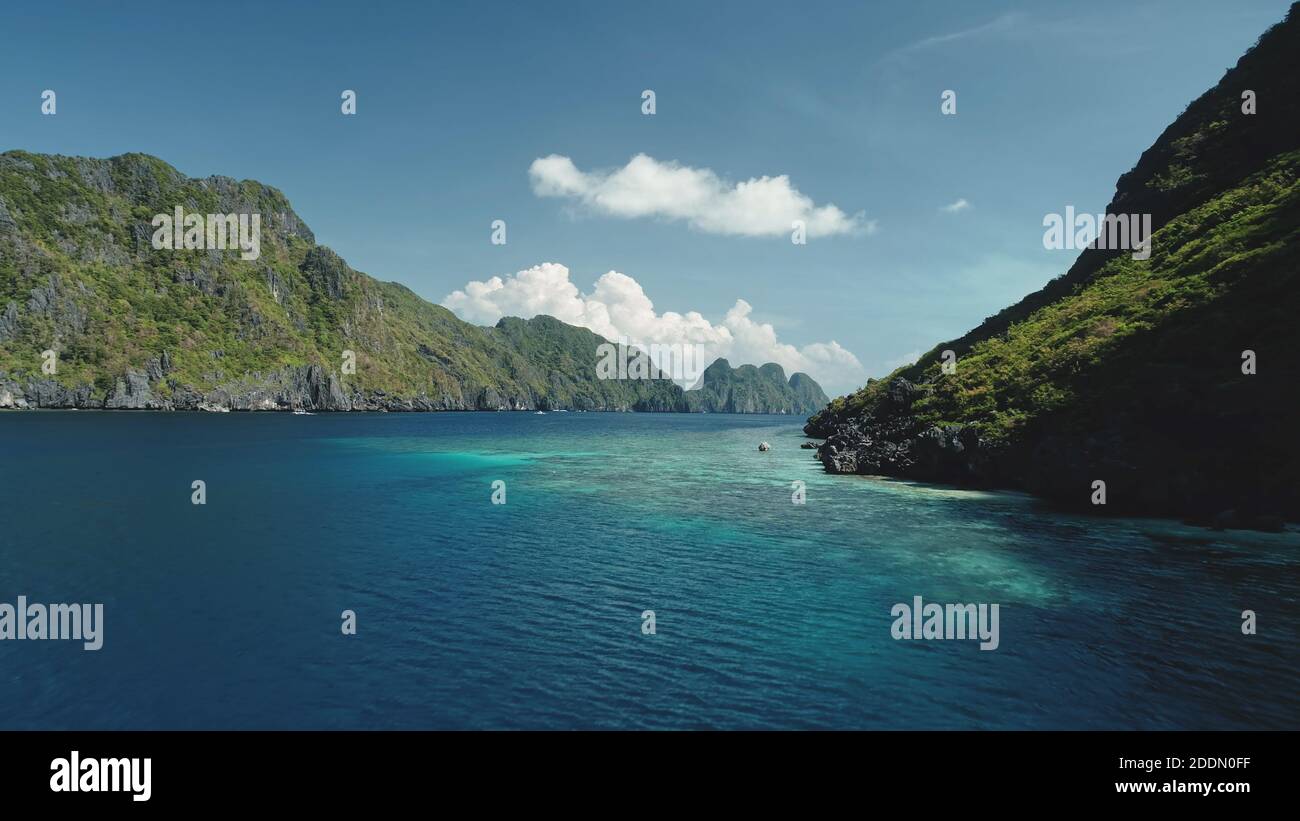 Vue aérienne de la baie de mer sur la falaise verte et sombre. Été personne paysage marin sur la côte rocheuse de l'océan avec turquoise et azur eau miroitant. Vacances épiques à Palawan, îles El Nido, archipel des Philippines Banque D'Images