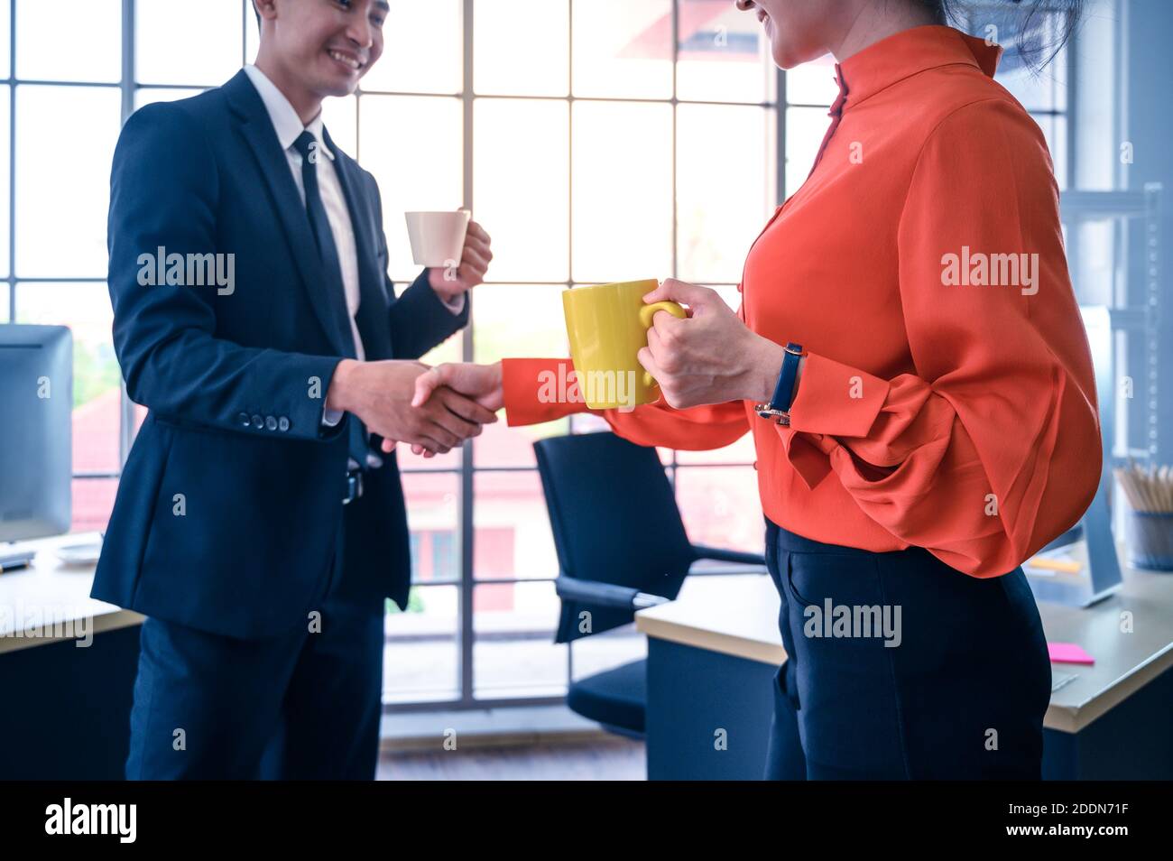 Partenaires commerciaux qui se secouent la main avec une tasse à café. Concept de coopération commerciale. Banque D'Images