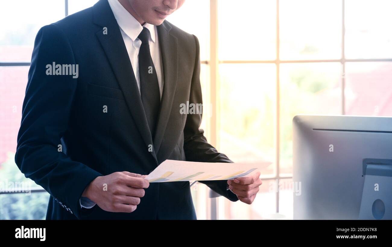 Homme d'affaires avec papier graphique sur le lieu de travail de bureau. Concept de gestion d'entreprise. Banque D'Images