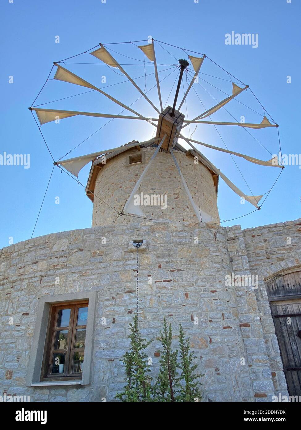 Ancien moulin à vent en pierre blanche avec vieille porte en bois lourde. Destination de vacances et attraction touristique. Banque D'Images