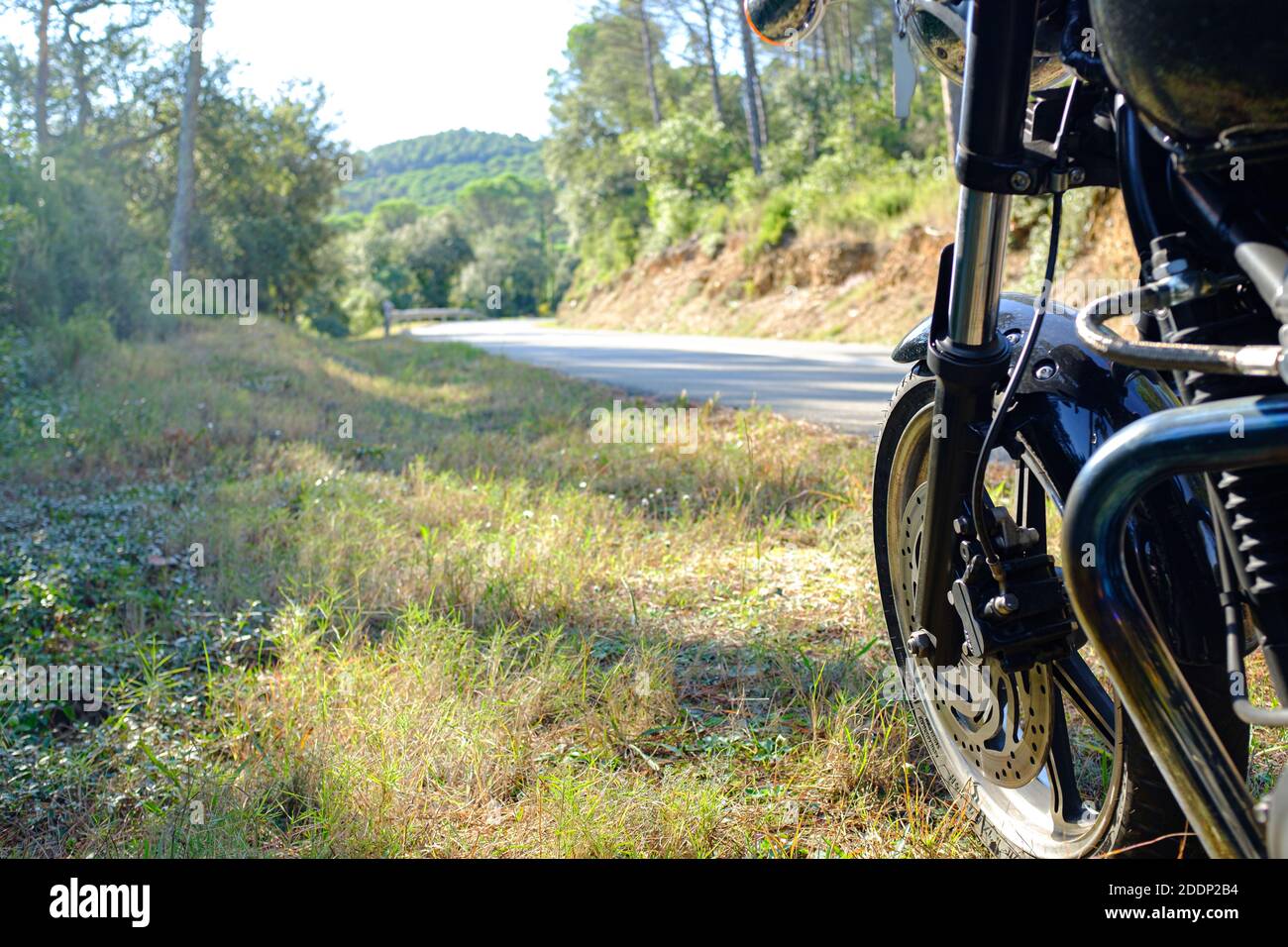 Moto noire garée au bord d'un enroulement rural route Banque D'Images