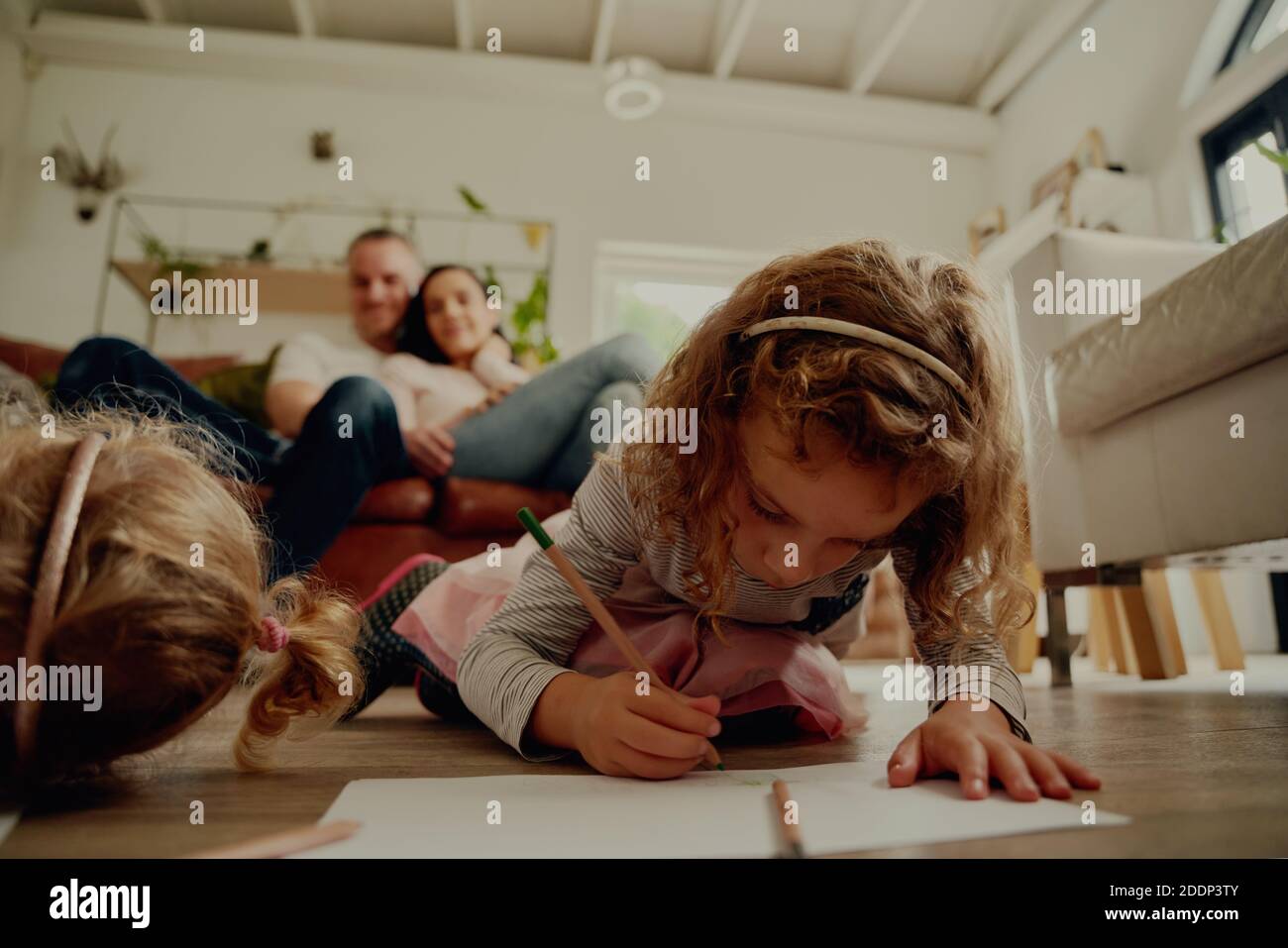 Petite fille d'âge préscolaire créant des œuvres d'art sur papier en utilisant le crayon à accueil pendant le verrouillage du virus corona Banque D'Images