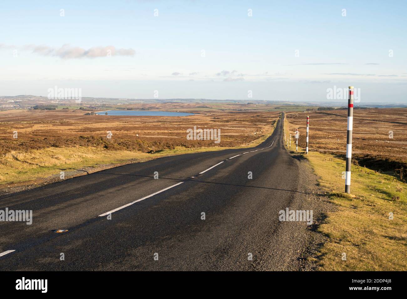 Vue d'automne de la route vide de la lande traversant Muggleswick Common à Weardale en direction de Castleside, Co. Durham, Angleterre, Royaume-Uni Banque D'Images