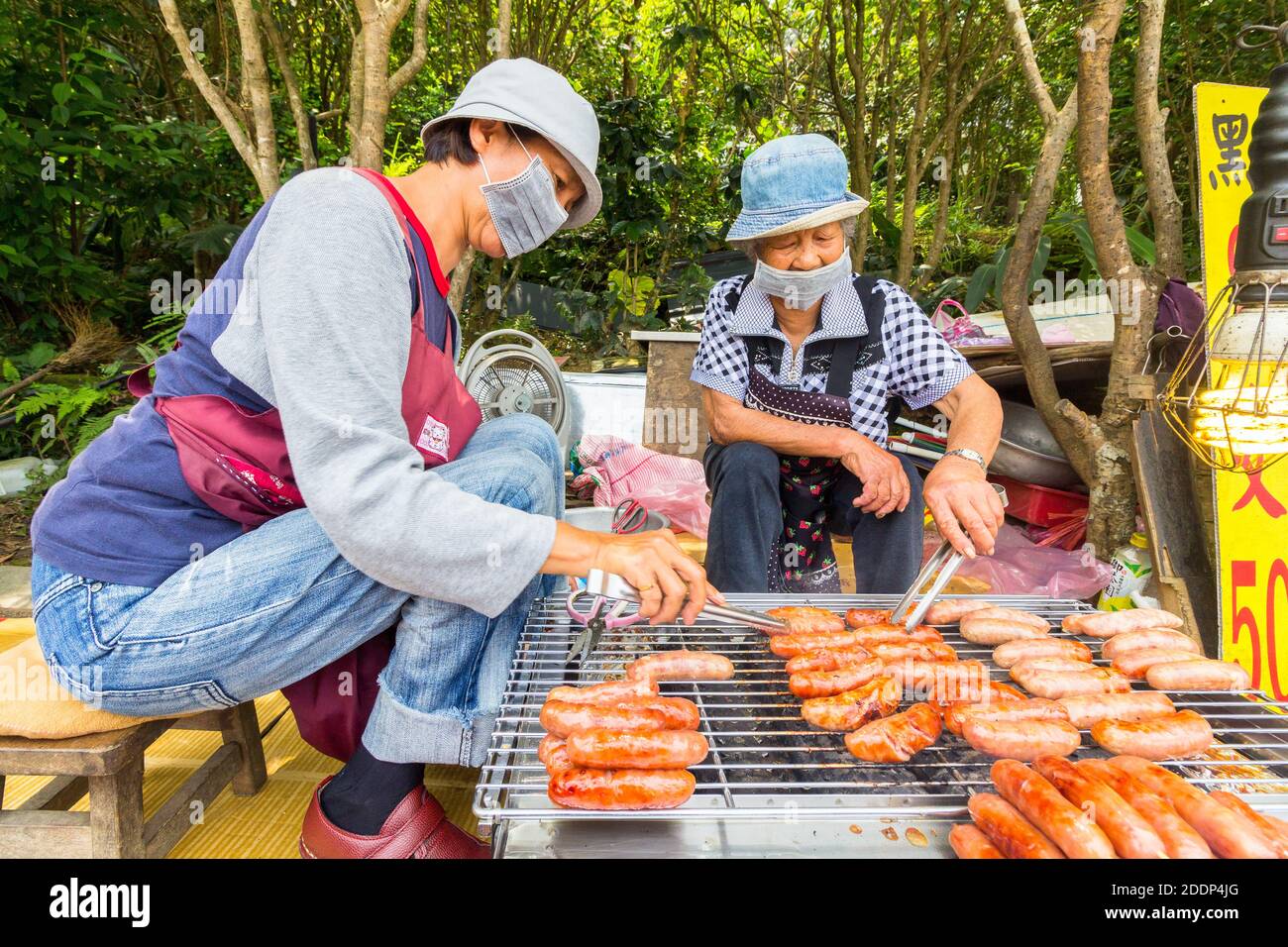 Deux vendeurs grillant de la nourriture le long d'une route à Taipei, Taiwan Banque D'Images