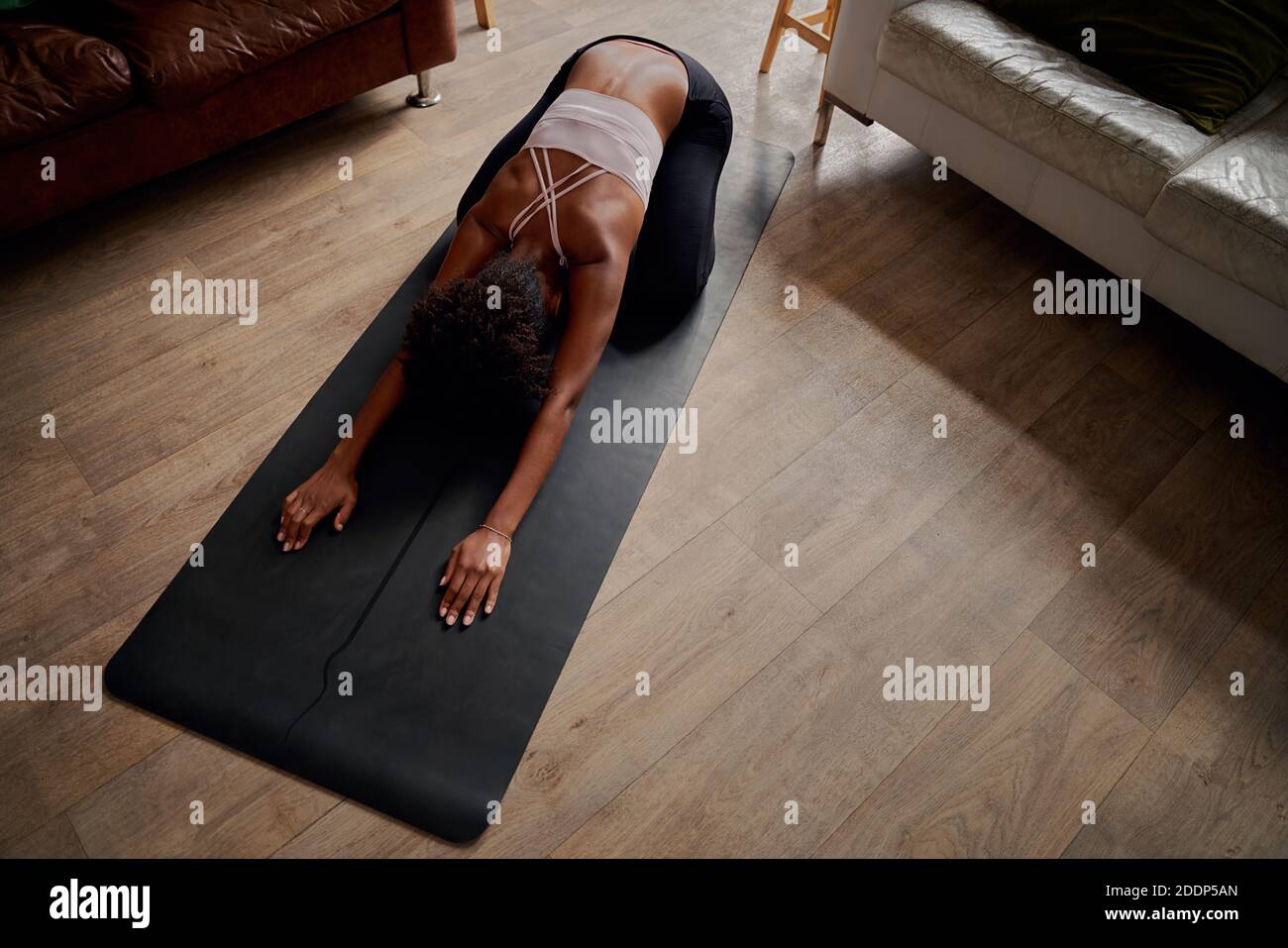 Vue en grand angle des femmes pratiquant des exercices de fitness à la maison pendant le verrouillage Banque D'Images