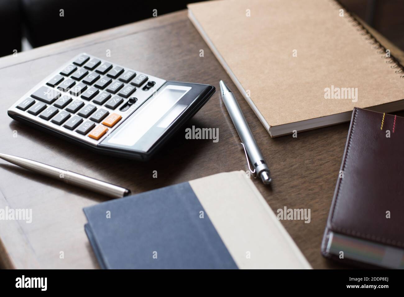 Carnets, stylos et calculatrice sur table en bois Banque D'Images