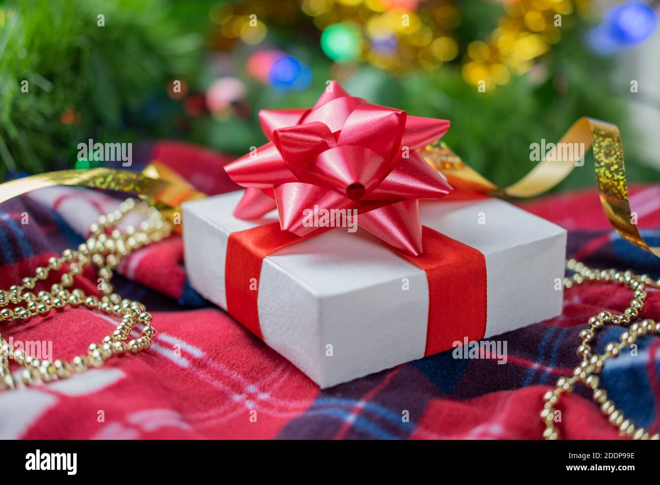 magnifique boîte cadeau surprise festive ornée d'un noeud rouge Un arrière-plan bokeh et près de l'arbre de Noël pour nouveau année et saint-valentin Banque D'Images