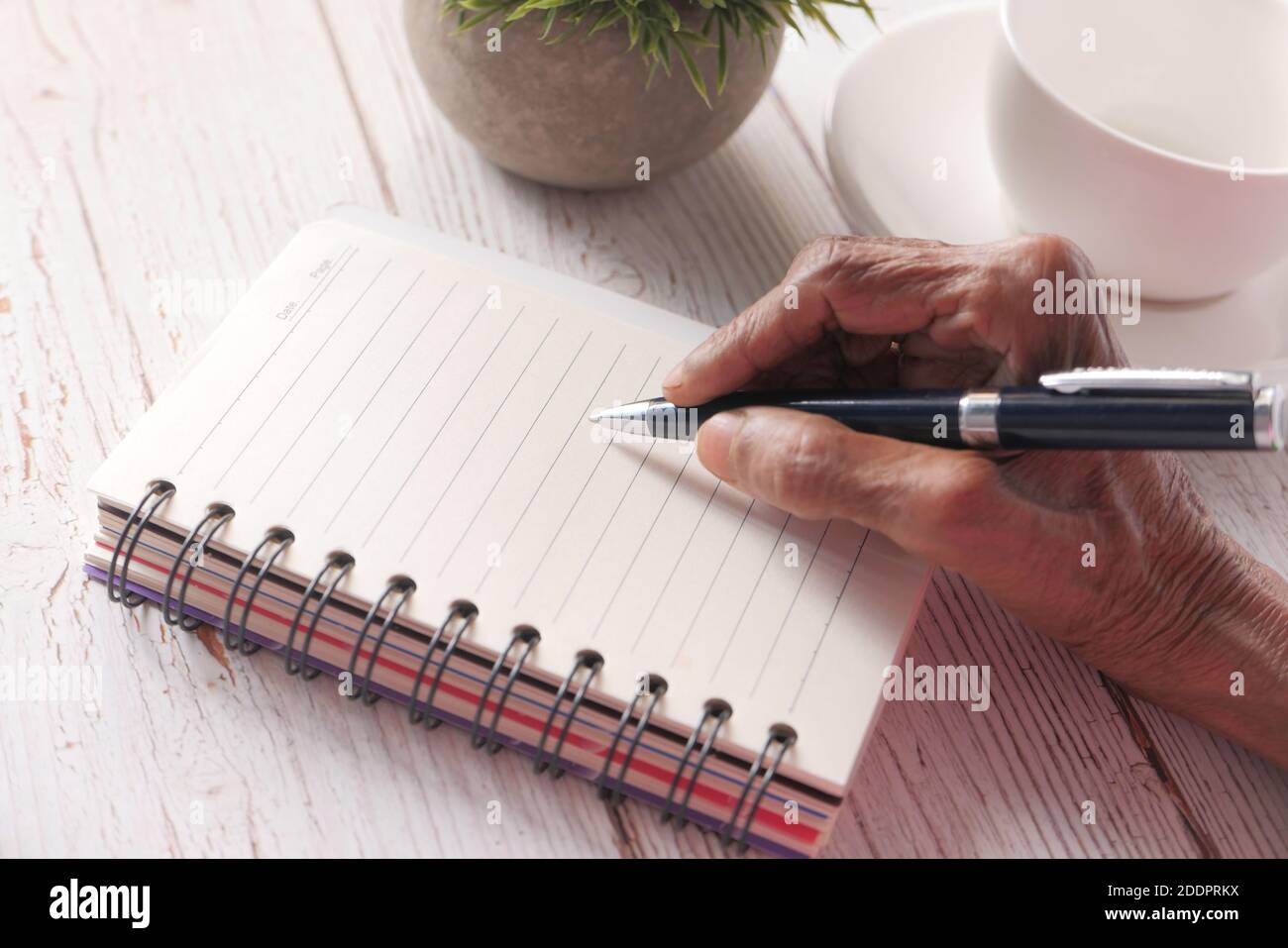 Gros plan sur l'écriture de main de femmes âgées sur le bloc-notes. Banque D'Images