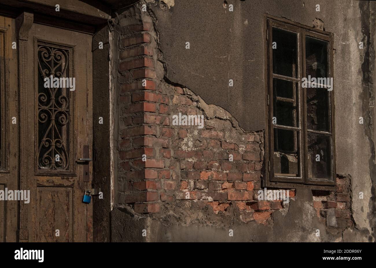 Ancienne façade en ruine avec une vieille fenêtre et un cadenas porte ...