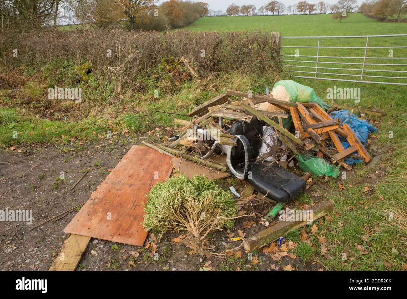 Les déchets de jardin et ménagers qui ont été déversés à l’entrée du champ d’un agriculteur bloquant la porte d’entrée. Dorset Angleterre GB Banque D'Images