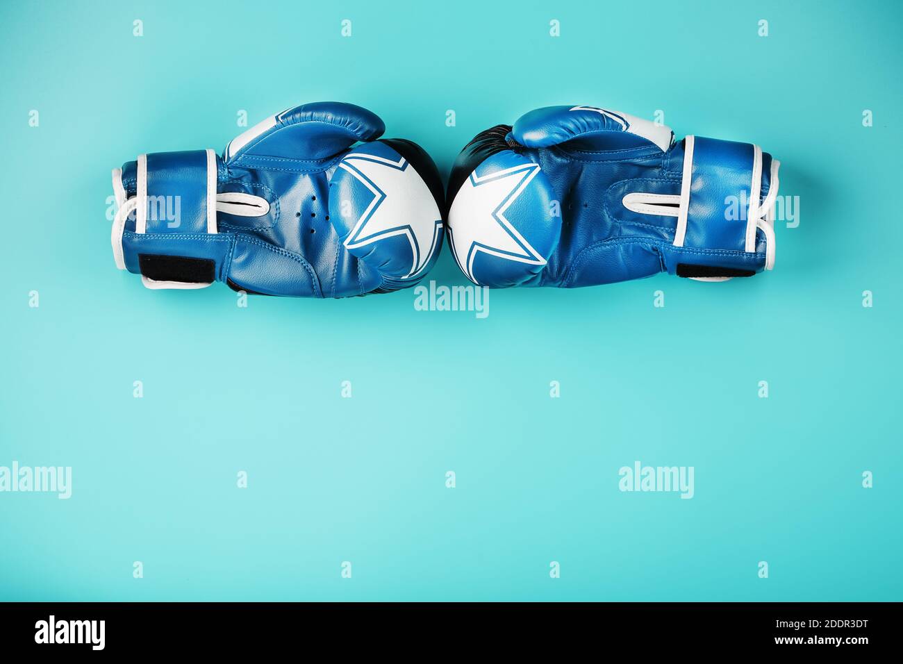 Une paire de gants de boxe en cuir sur fond bleu, espace libre. Le concept de lutte et de lutte avec difficultés. Banque D'Images