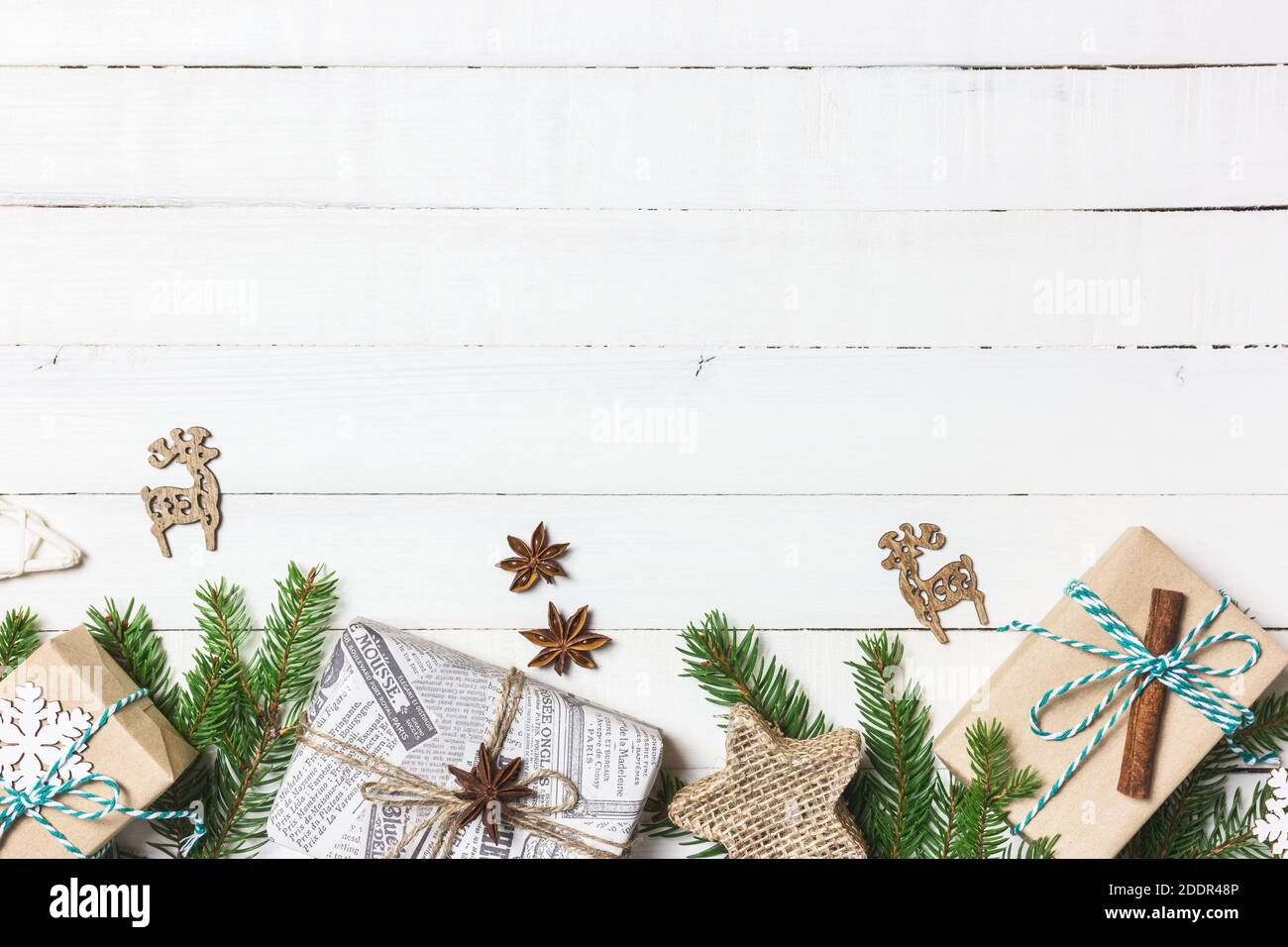 Composition de Noël ou d'hiver. Cadeaux de Noël, branches de sapin et ornements sur fond blanc en bois. Flat lay, vue de dessus, espace de copie. Banque D'Images