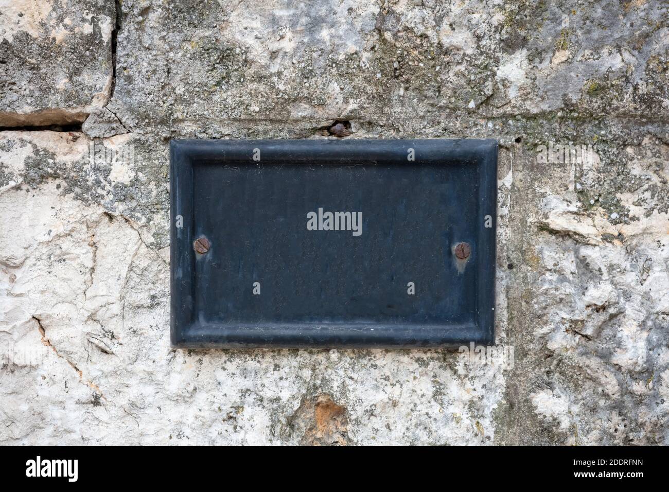 Numéro de rue, plaque en métal vierge vintage montée sur un mur en pierre. Modèle d'adresse maison traditionnel, espace de copie Banque D'Images