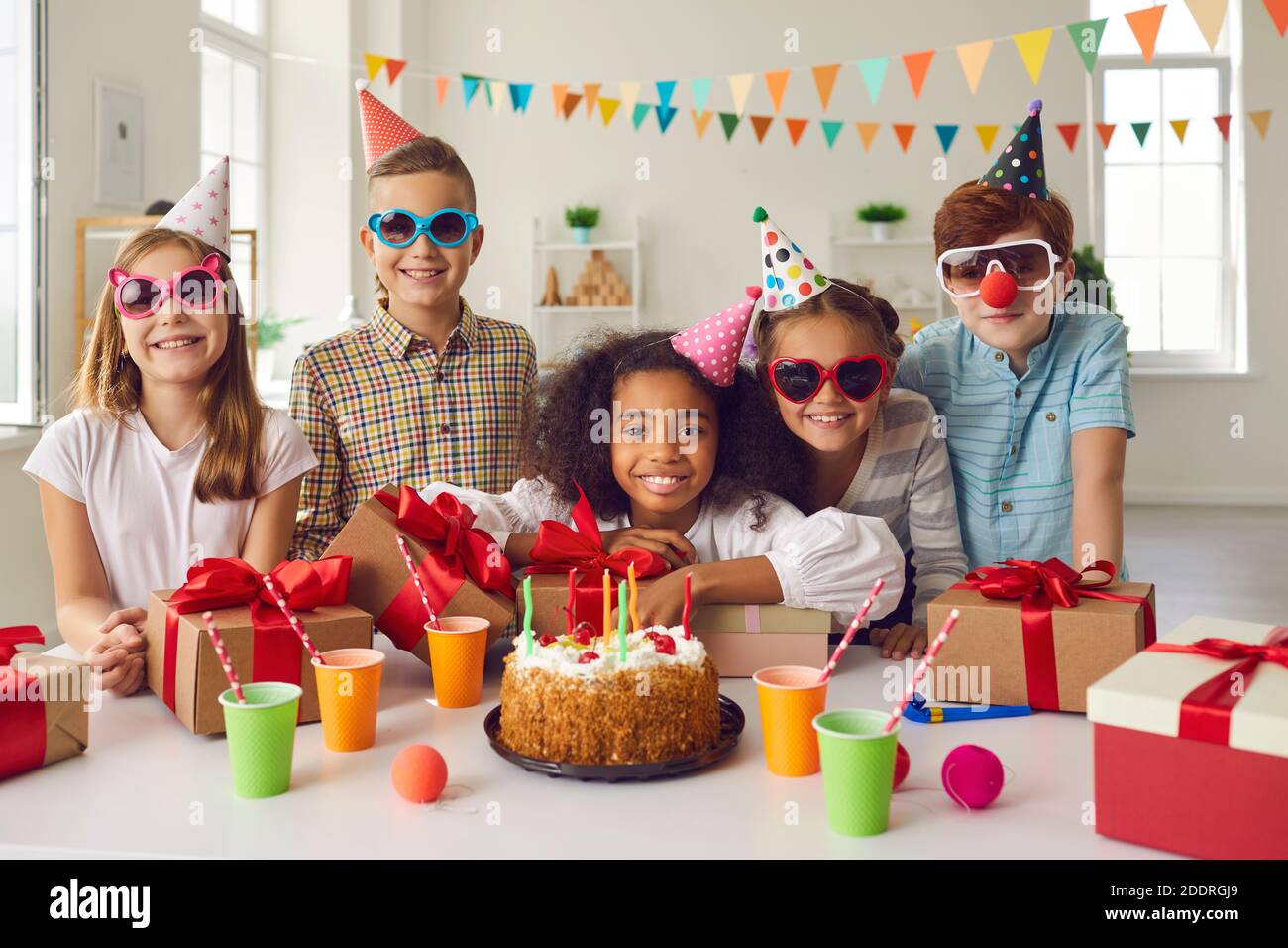 Portrait d'une fille d'anniversaire afro-américaine avec ses amis qui sont à la table avec des cadeaux. Banque D'Images