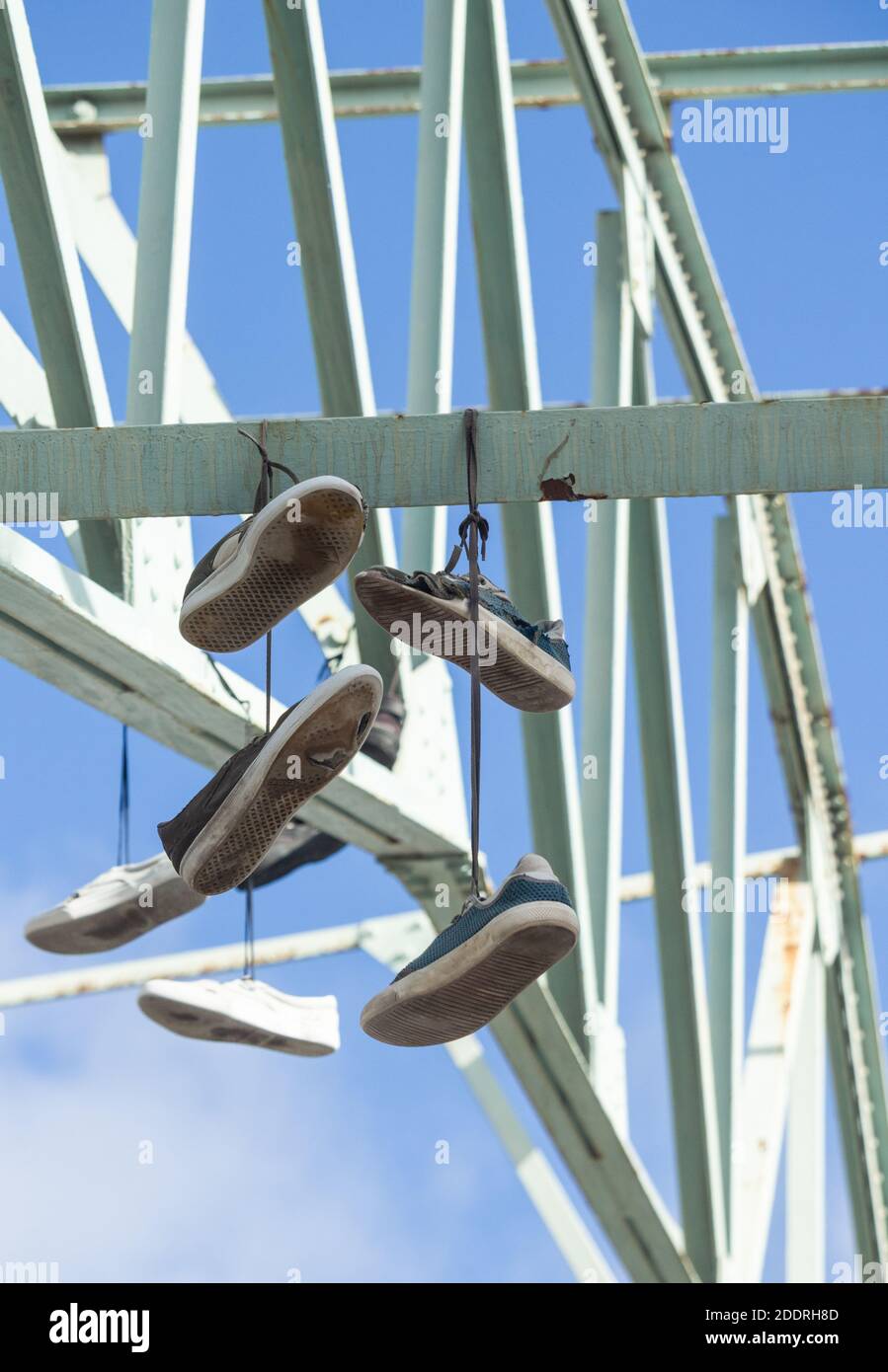 Anciennes baskets, chaussures d'entraînement suspendues à des poutres en acier, Banque D'Images