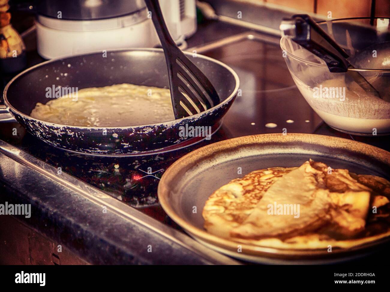 Cuisiner à la maison : faire des crêpes dans la poêle pour un petit déjeuner festif Banque D'Images