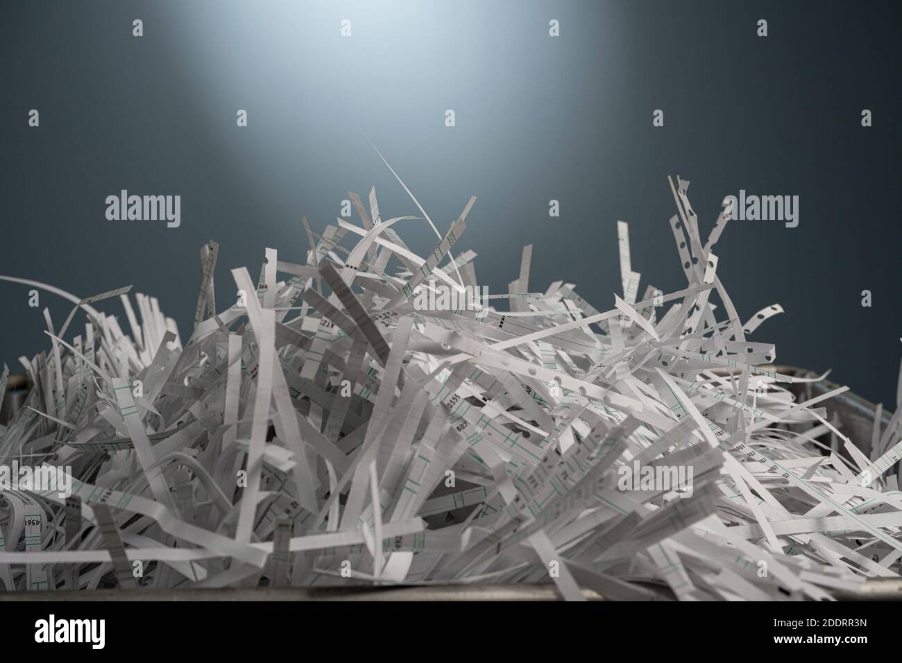 Vue rapprochée avec profondeur optique de feuilles de papier blanches coupées en bandes devant un mur bleu. Banque D'Images