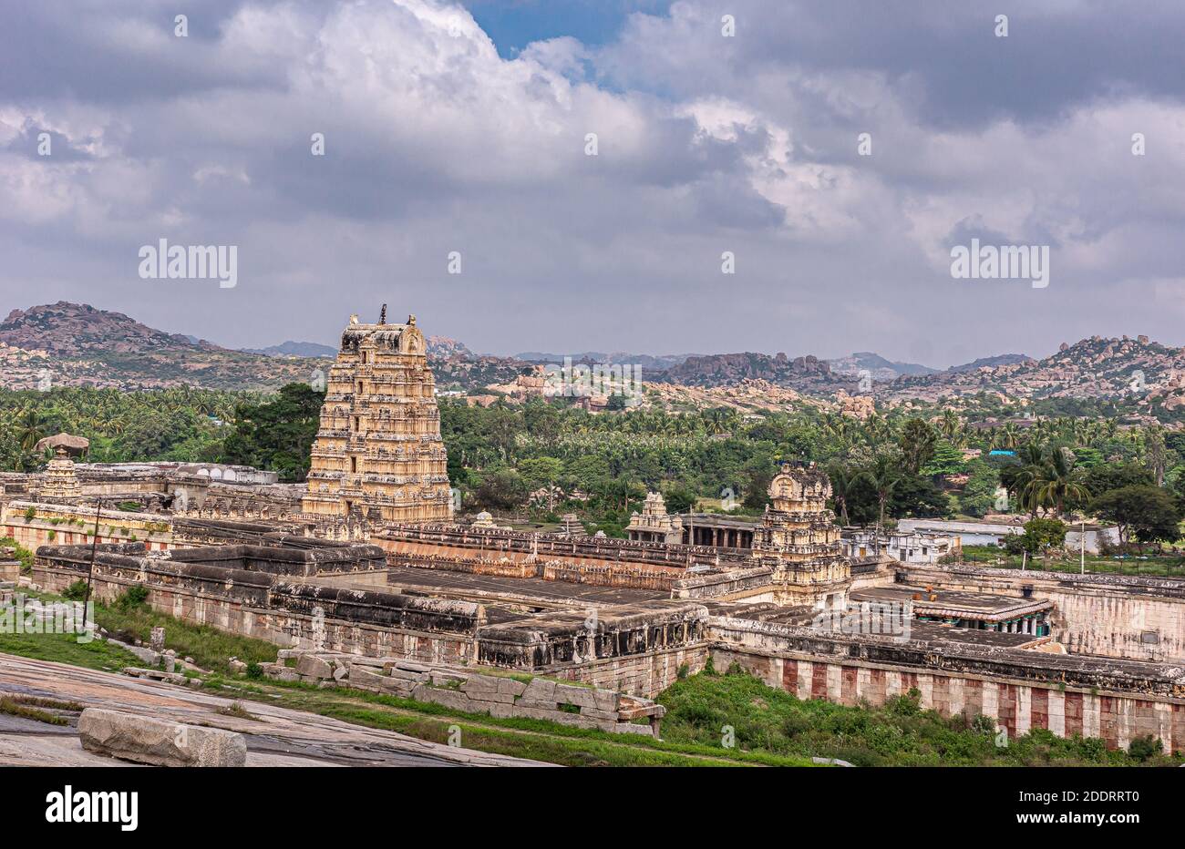 Hampi, Karnataka, Inde - 4 novembre 2013 : complexe du temple de Virupaksha. Paysage large avec des forêts et des collines rocheuses brunes derrière sous le paysage bleu de nuages. Banque D'Images