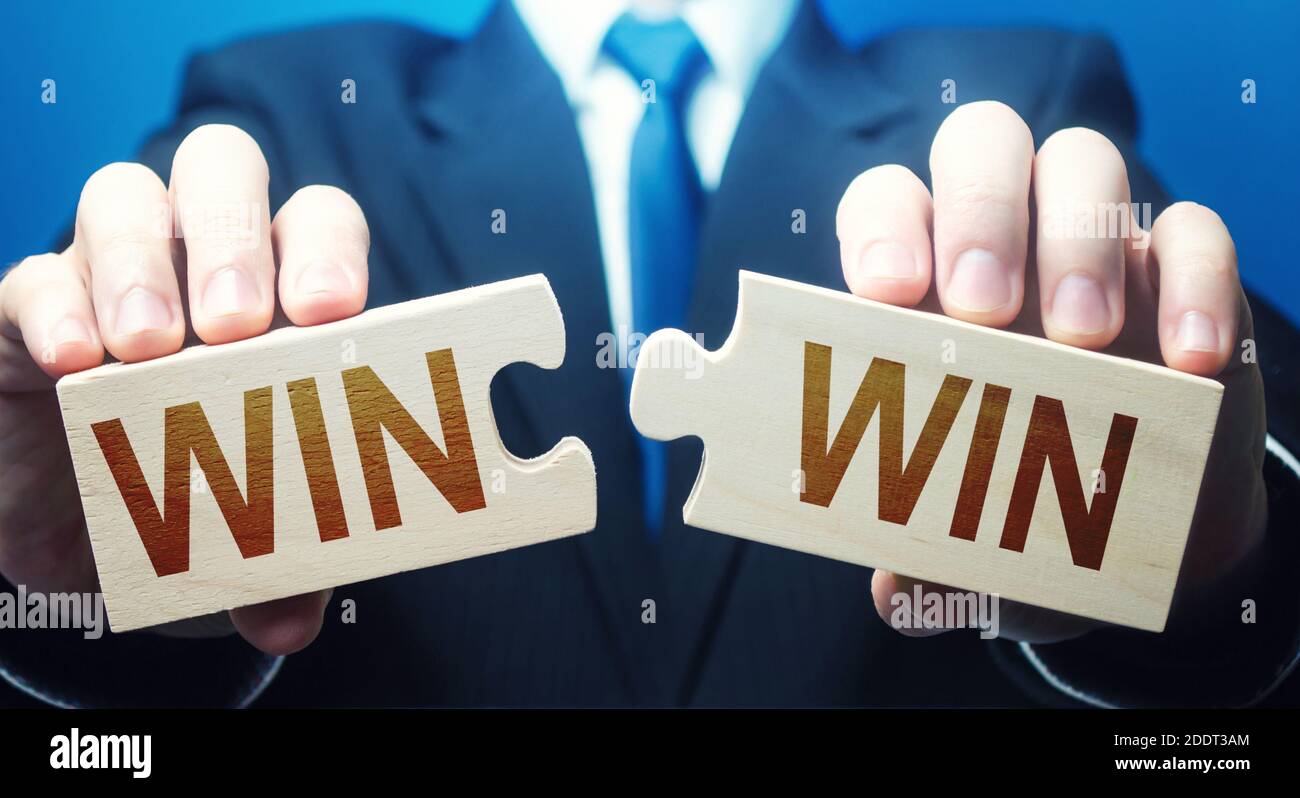 Homme tenant deux puzzles avec des mots Win-Win. Une stratégie de négociation permet à toutes les parties de réussir. Avantages mutuels et bonnes conditions contractuelles. Compromis, perf Banque D'Images