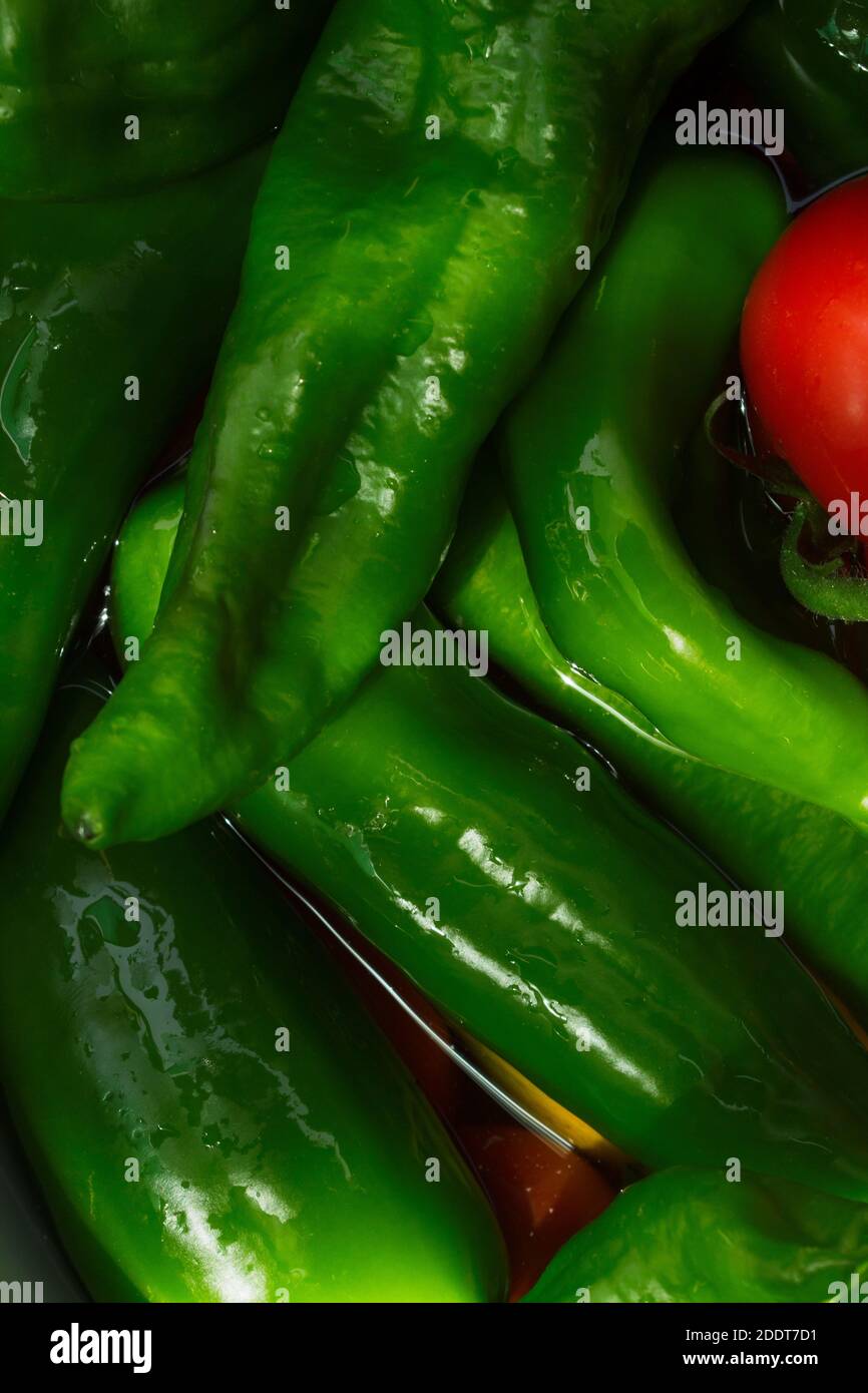 Un cliché détaillé de légumes dans l'eau. Poivrons verts, tomates et oranges. Banque D'Images