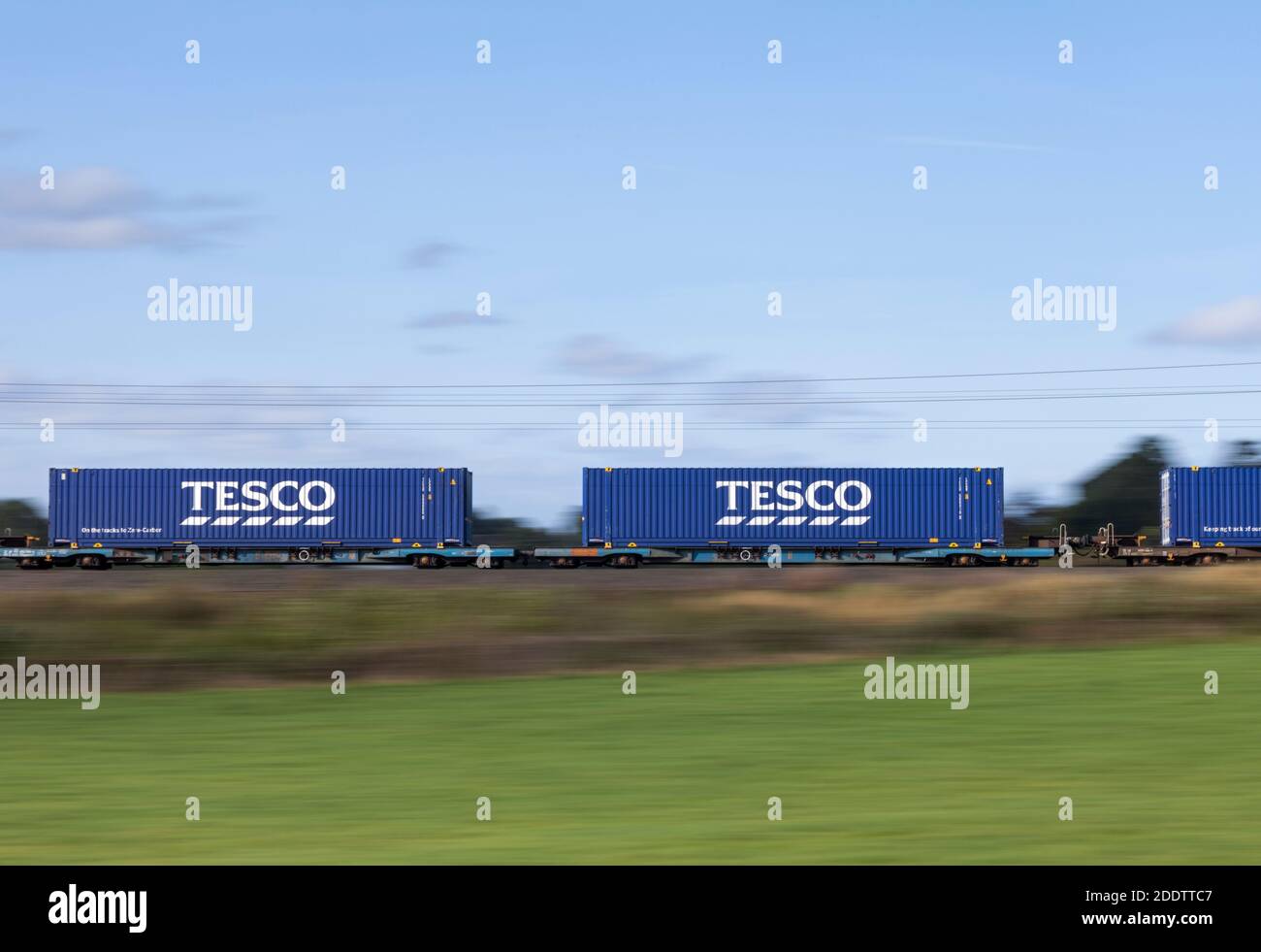 Le conteneur intermodal Tesco/Stobart étant transporté sur un train de marchandises à grande vitesse sur la ligne principale de la côte ouest. Panoramique avec flou de mouvement Banque D'Images