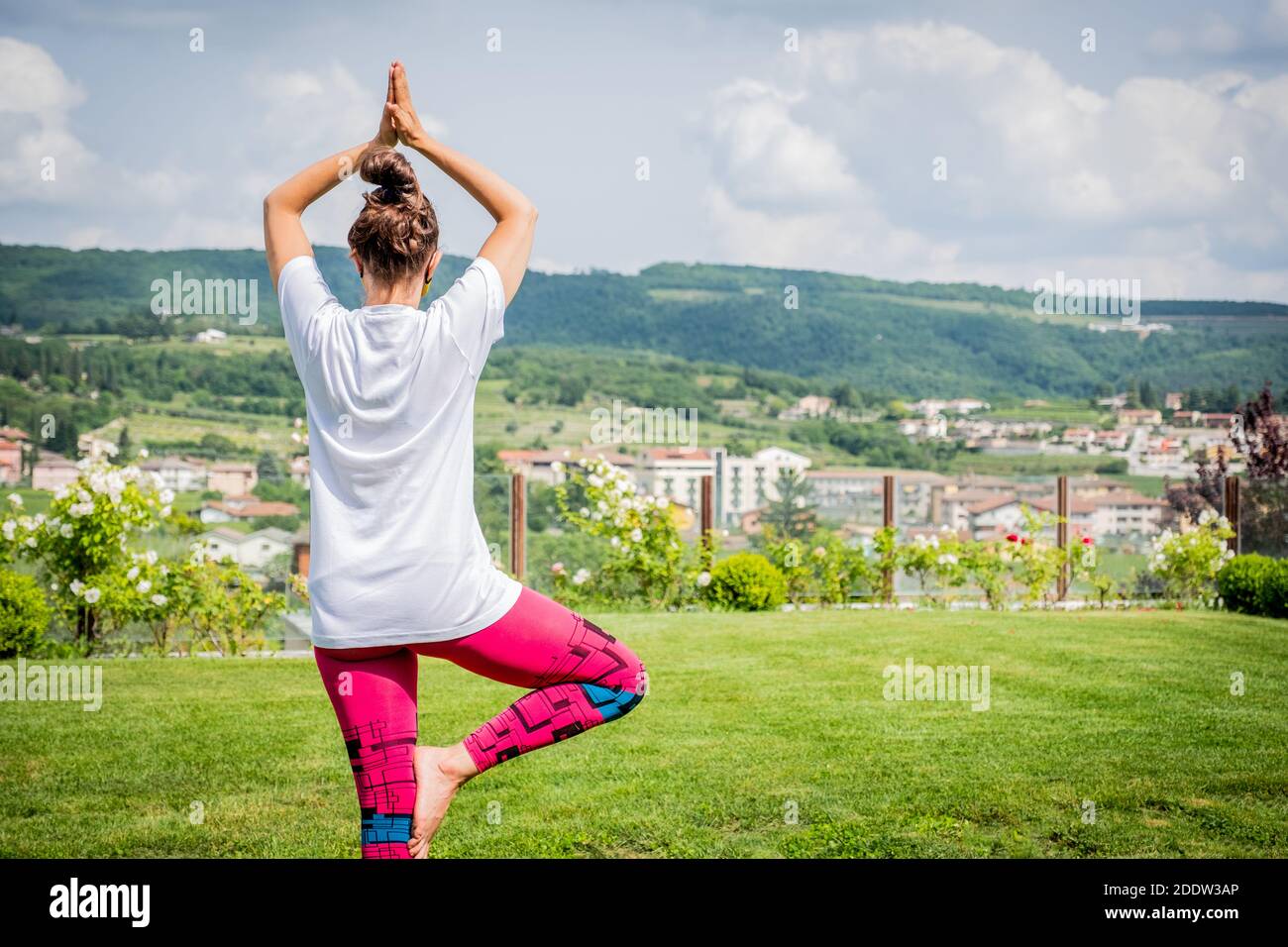 Belle femme faisant du yoga dans le jardin avec beau paysage - jeune mère fait une pose de yoga pour l'équilibre et l'étirement - Fitness maman Banque D'Images