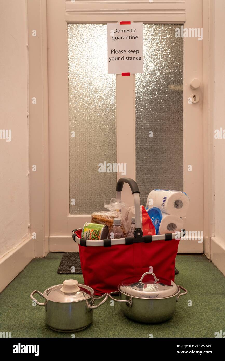 Image symbolique quarantaine domestique, l'homme est soupçonné d'infection corona, à la maison en isolement, signe d'avertissement pour les visiteurs à la porte plate, communicat Banque D'Images