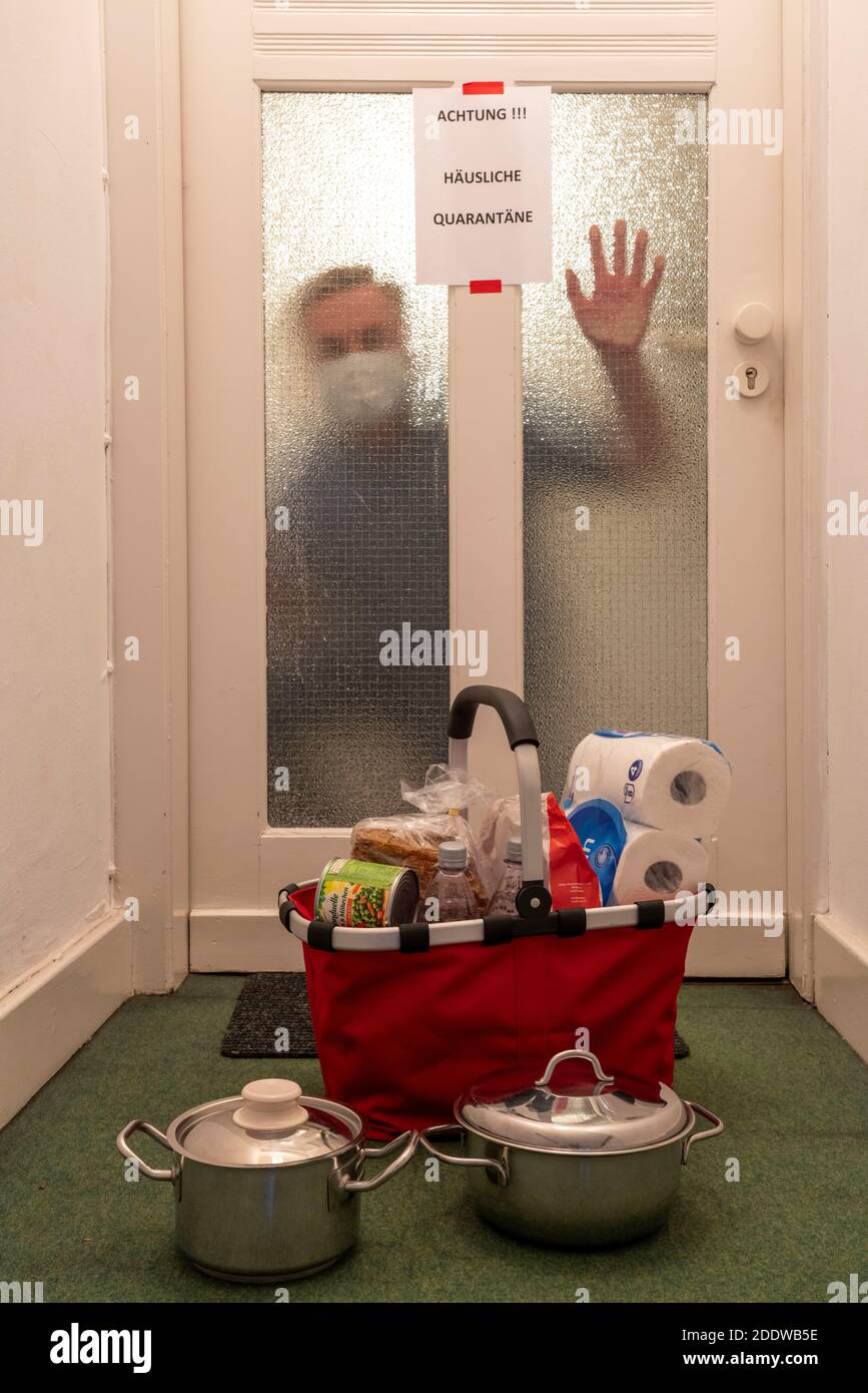 Image symbolique quarantaine domestique, l'homme est soupçonné d'infection corona, à la maison en isolement, signe d'avertissement pour les visiteurs à la porte plate, communicat Banque D'Images