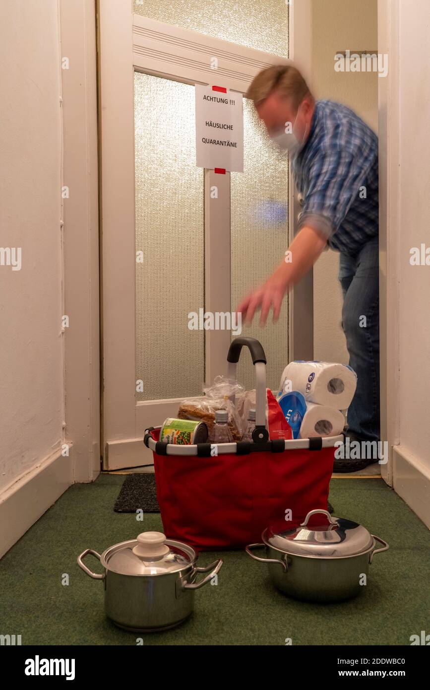 Image symbolique quarantaine domestique, l'homme est soupçonné d'infection corona, à la maison en isolement, signe d'avertissement pour les visiteurs à la porte plate, communicat Banque D'Images