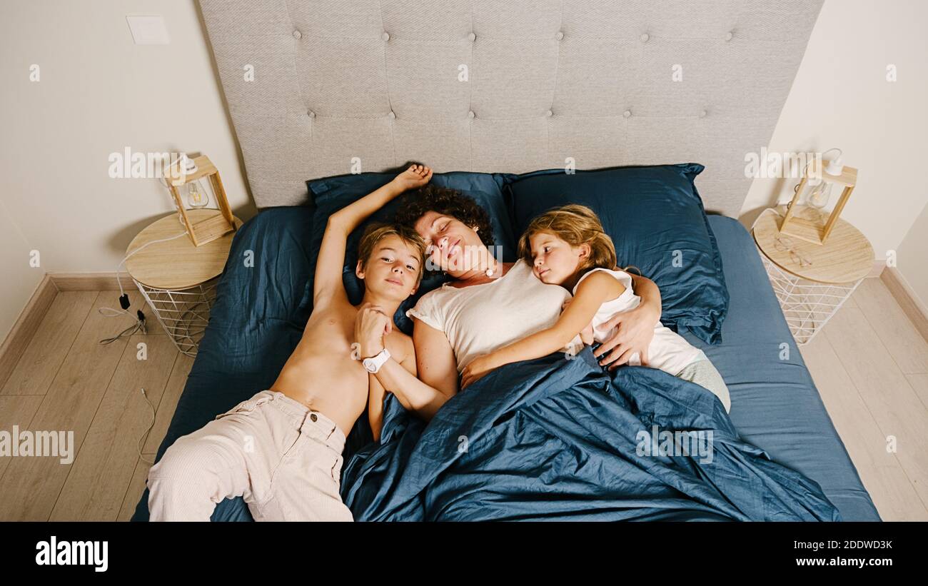 Photo de la jeune mère et de ses enfants au lit. Banque D'Images