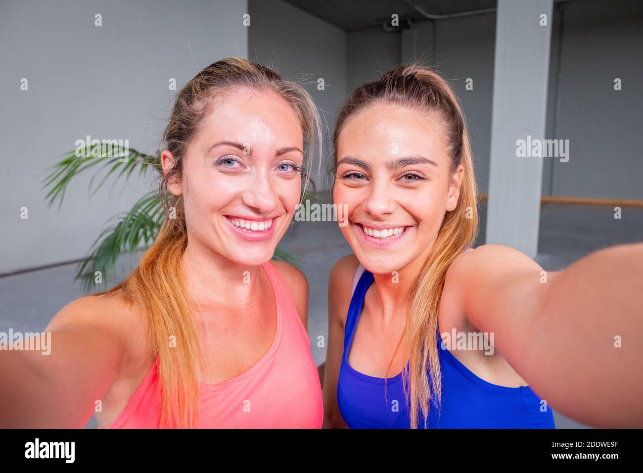 Deux filles sportives prenant une photo de selfie avec un téléphone portable À la salle de gym - deux belles amies qui prennent un selfie photo après un entraînement intensif en salle de gym Banque D'Images