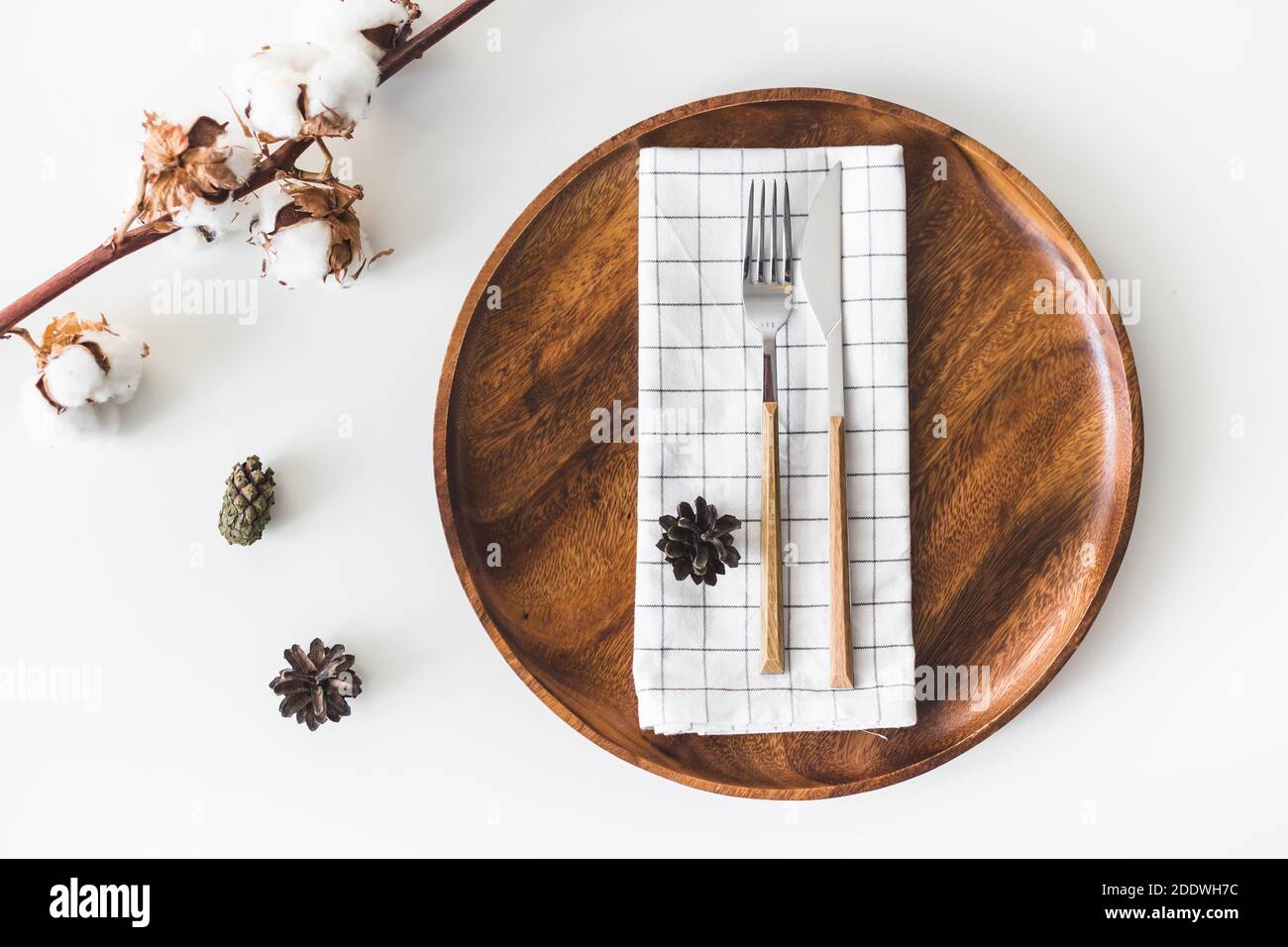 Mariage féminin, scène de bureau d'anniversaire. Plat en bois, couverts avec serviette à carreaux, fleurs en coton. Arrière-plan de table blanc. Plat, dessus Banque D'Images