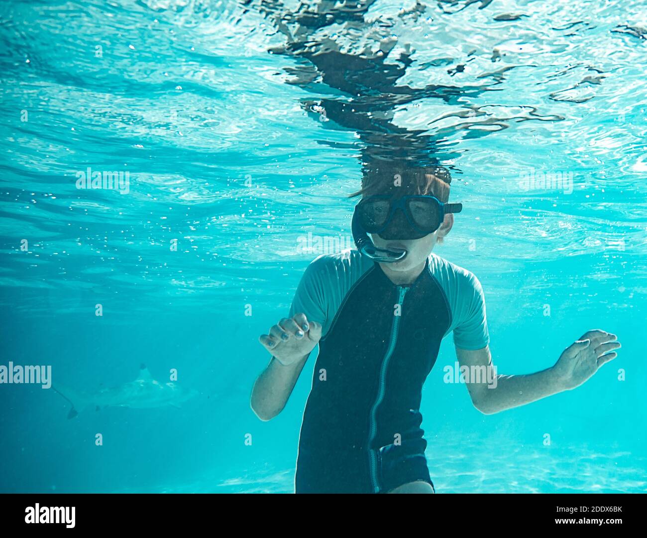 Photo d'un jeune garçon portant des lunettes de plongée en regardant la caméra. Banque D'Images