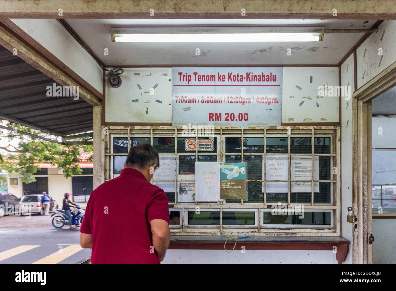 Un passager achetant un billet d'autobus pour Kota Kinabalu à un terminal de bus à Tenom, Sabah, Malaisie Banque D'Images
