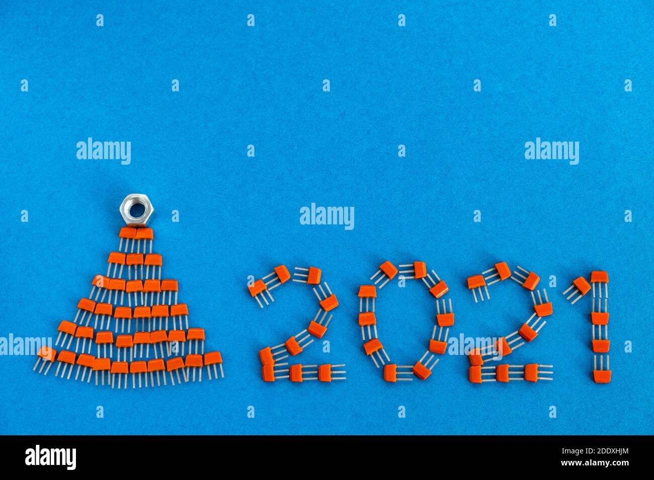 Carte de Noël créative. Numéros 2021 et un arbre de Noël fait de transistors sur un fond bleu. Concept créatif de la nouvelle année. Copier l'espace. Banque D'Images