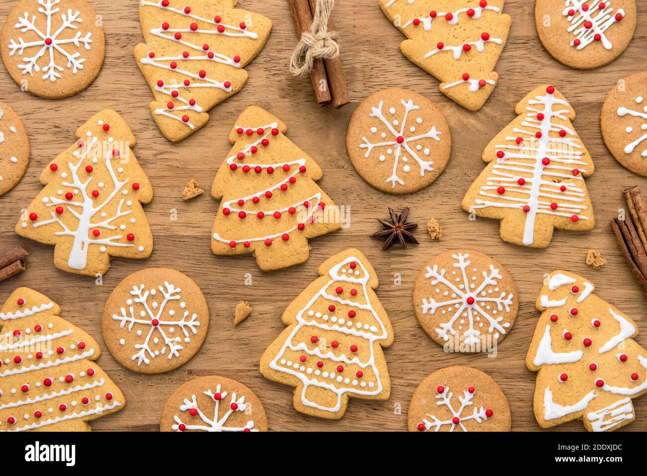 Biscuits de pain d'épice de Noël décorés de façon festive sur fond de bois, vue du dessus Banque D'Images