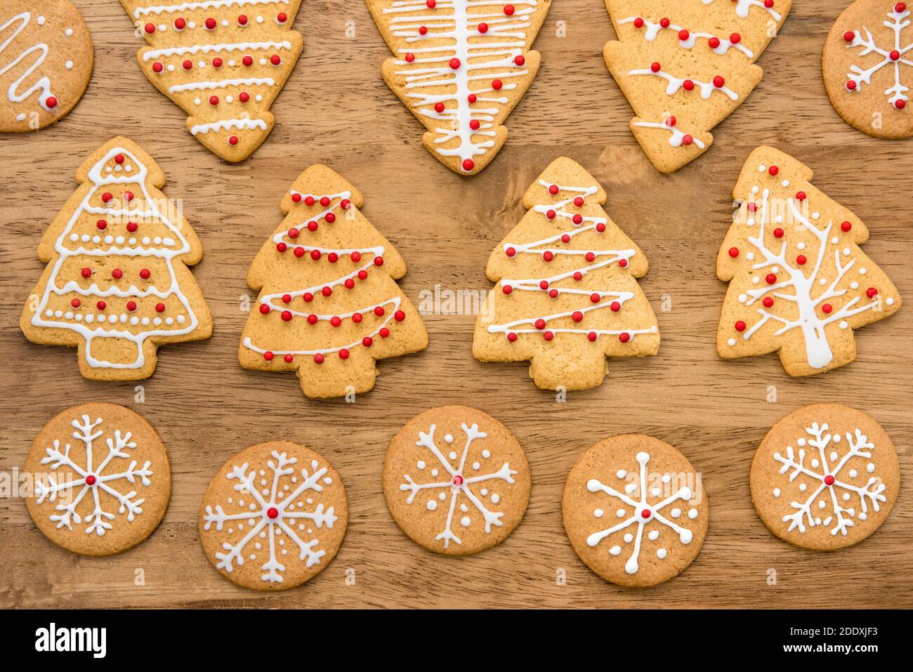 Biscuits de pain d'épice de Noël décorés de façon festive sur fond de bois, vue du dessus Banque D'Images