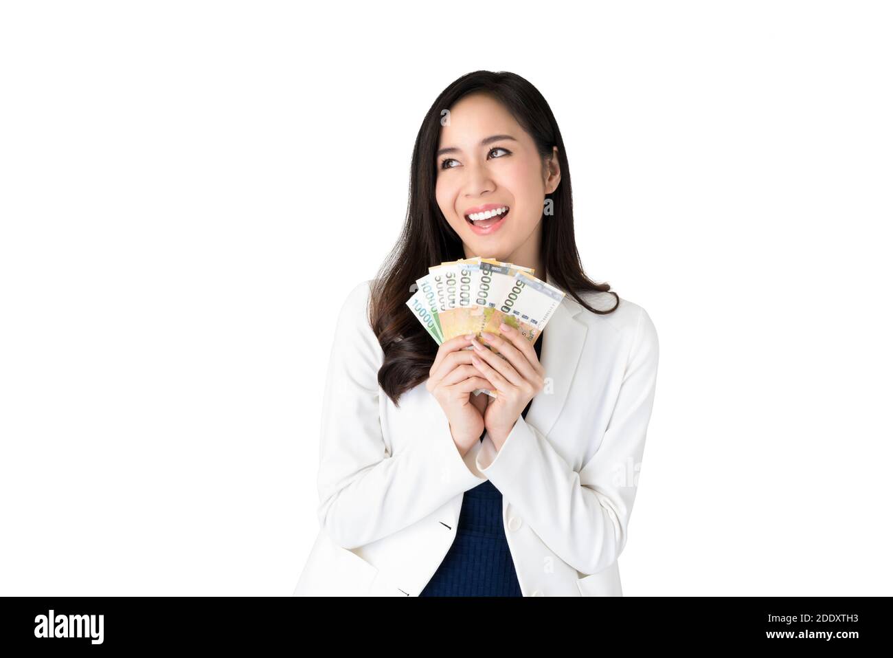 Belle femme asiatique pensant et souriant en tenant la Corée du Sud a gagné de l'argent en mains isolées sur fond blanc Banque D'Images