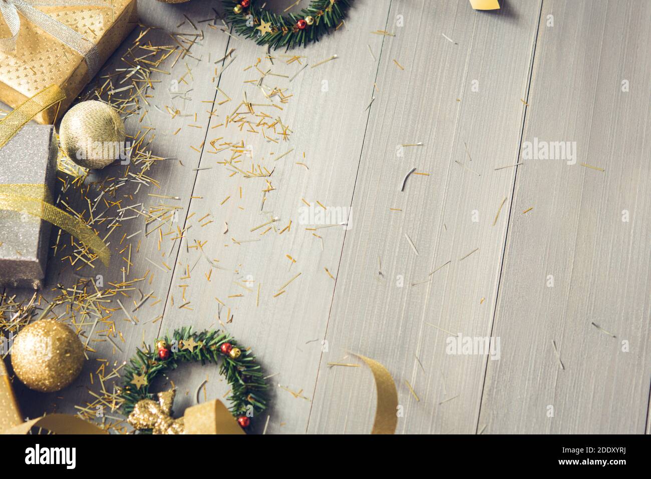 Boîtes-cadeaux argentées et dorées et articles de décoration de Noël étincelants sur fond de bois, vue de dessus avec espace de copie Banque D'Images