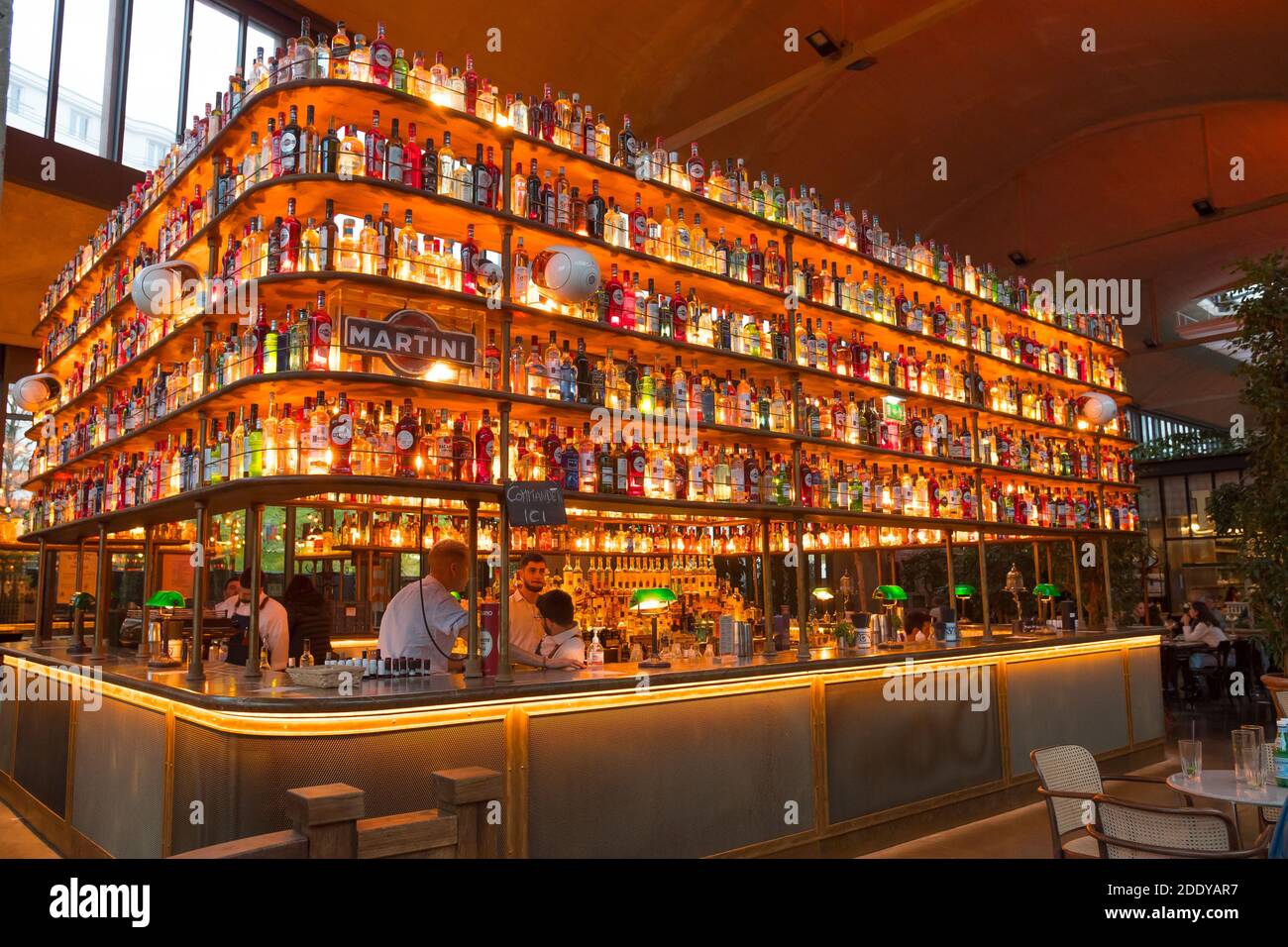 Beau comptoir de bar intérieur recouvert de bouteilles d'alcool illuminées. La Felicita (Big mamma, Station F), Paris, France. Banque D'Images