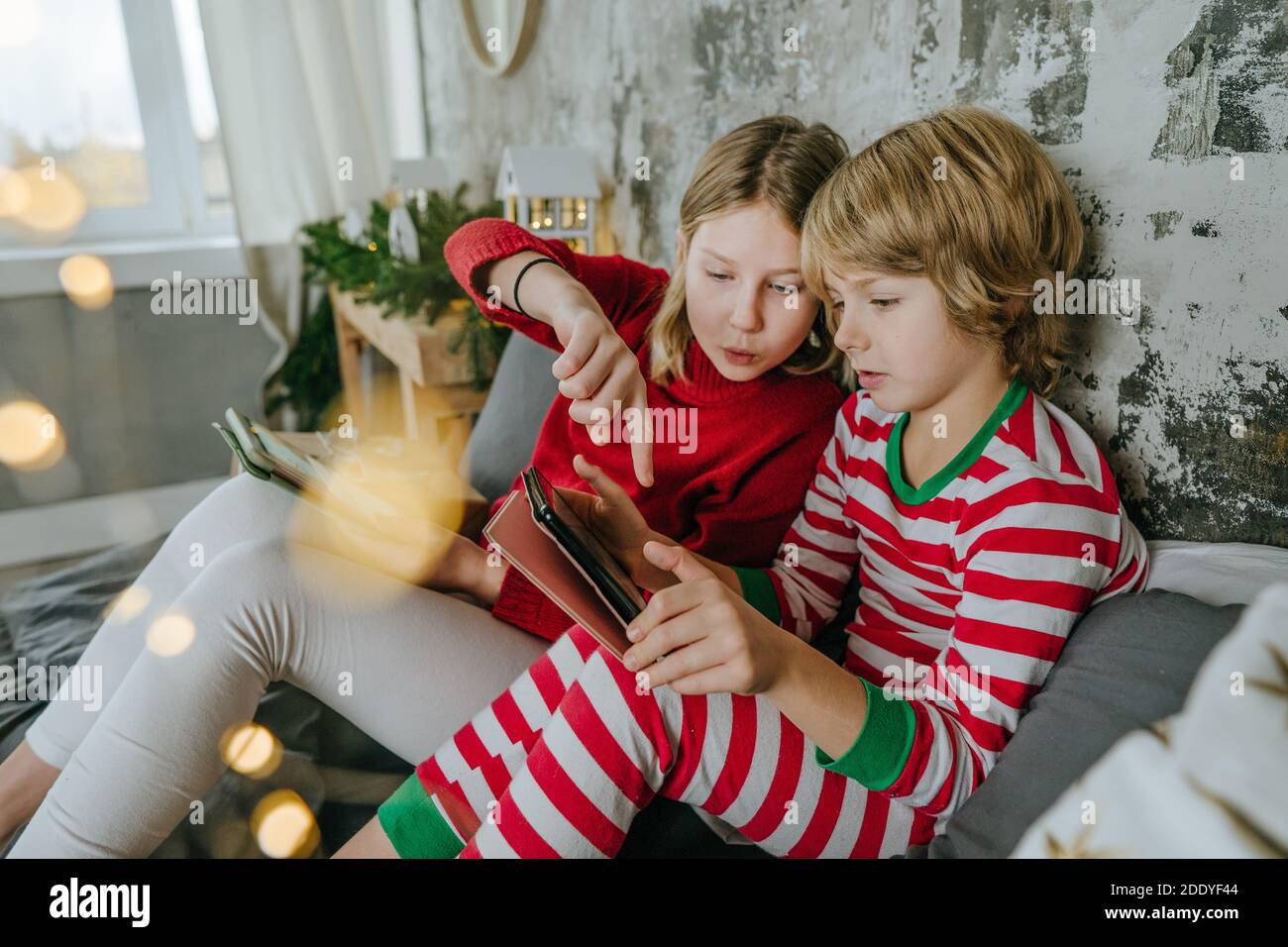 Garçon et fille utilisant des comprimés à l'heure de Noël. Mise au point sélective. Banque D'Images