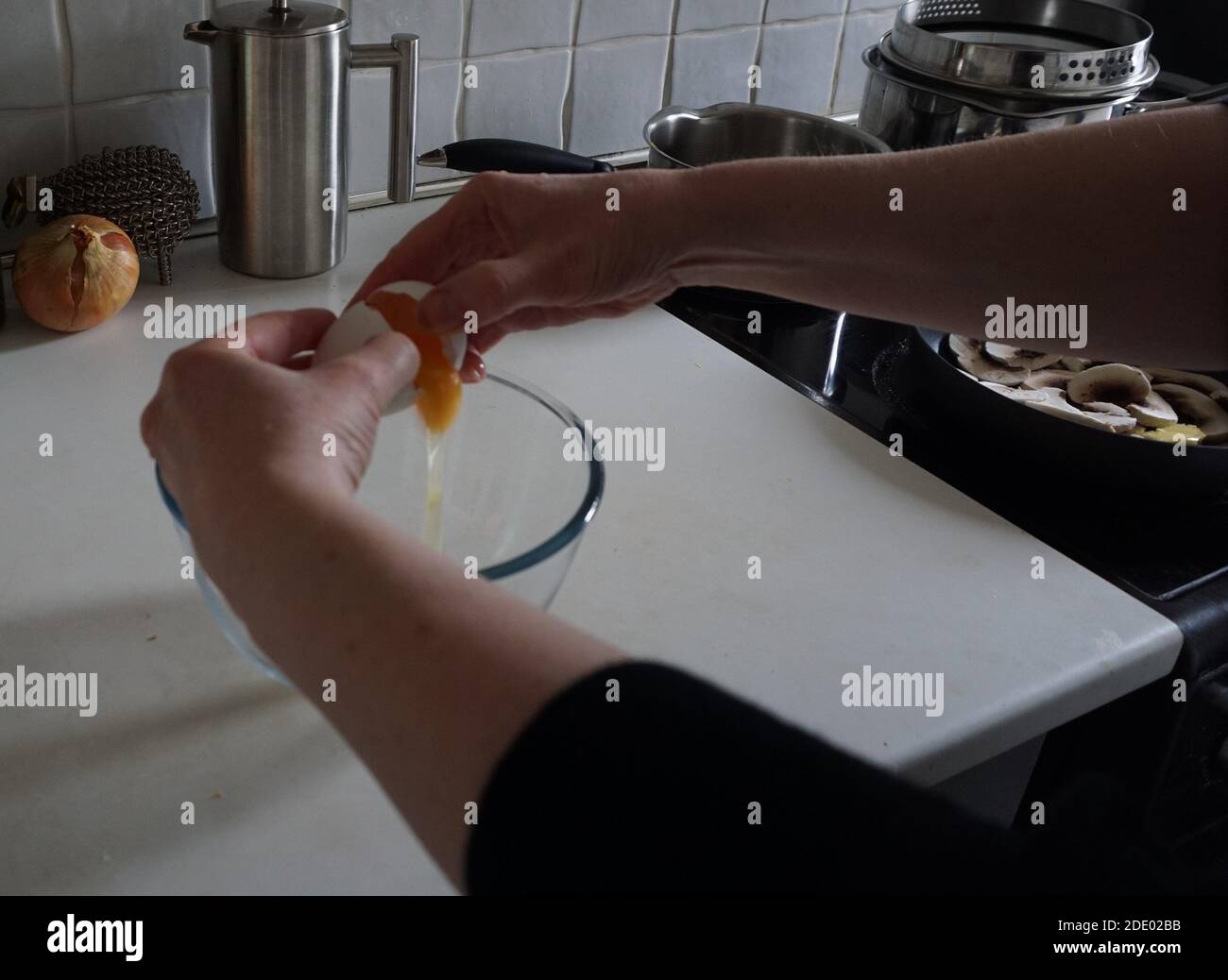 Fendre l'œuf dans le bol pour omelette Banque D'Images